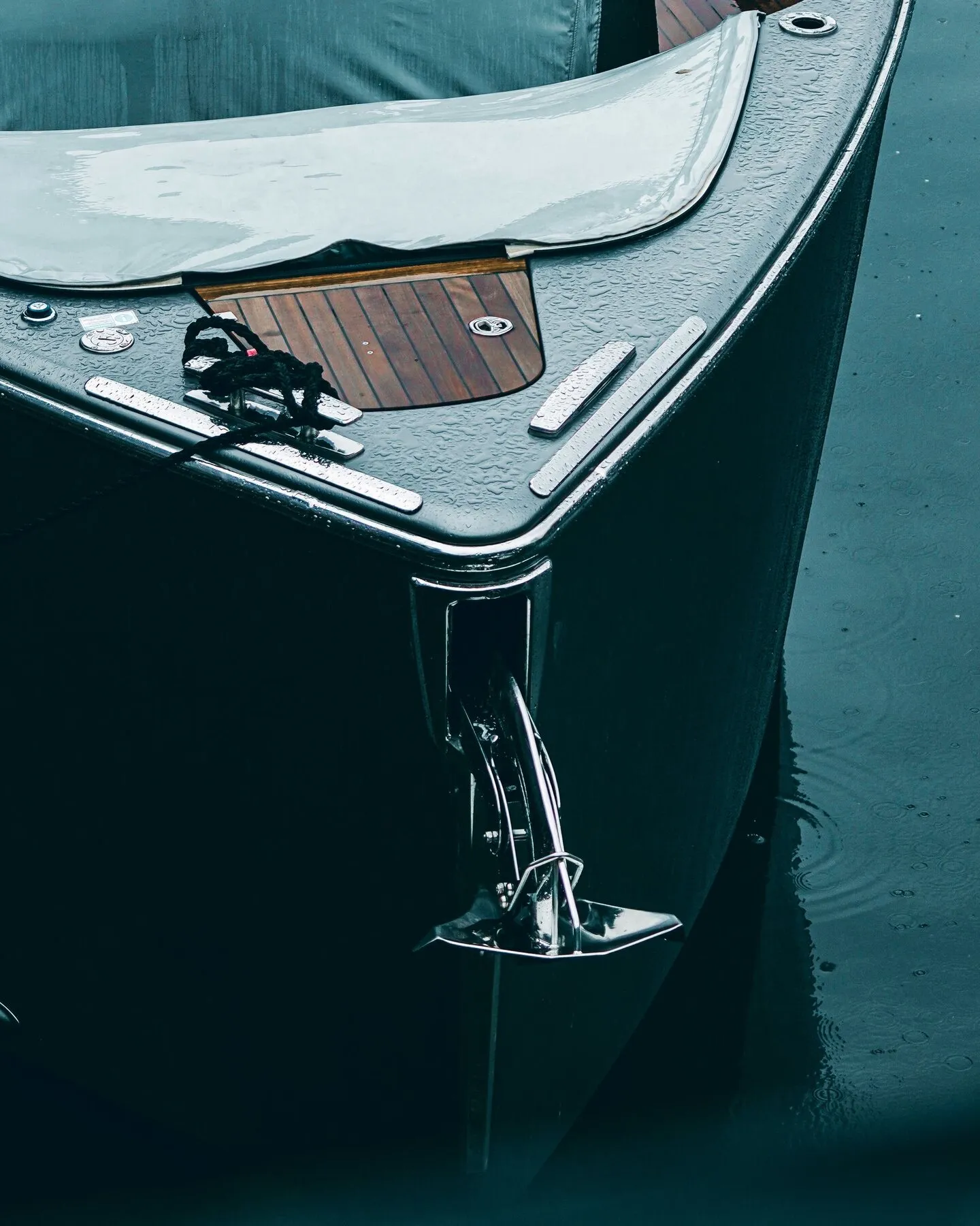 Dark bow of a yacht at anchor on calm water
